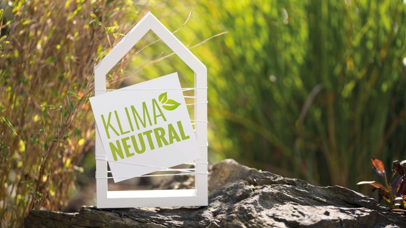 Symbolbild Klimaneutralität: Miniaturhaus mit Schild 